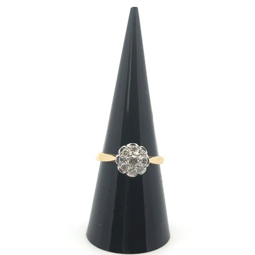 64 - A modern 18ct yellow and white gold flower ring set with nine diamonds. Size O. Principal diamond 0.... 