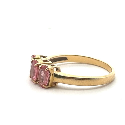 50 - A three stone pink sapphire ring in 18ct yellow gold. Size N. Sapphires each 6mm x 4mm. Hallmarks fo... 