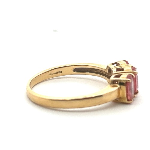 50 - A three stone pink sapphire ring in 18ct yellow gold. Size N. Sapphires each 6mm x 4mm. Hallmarks fo... 