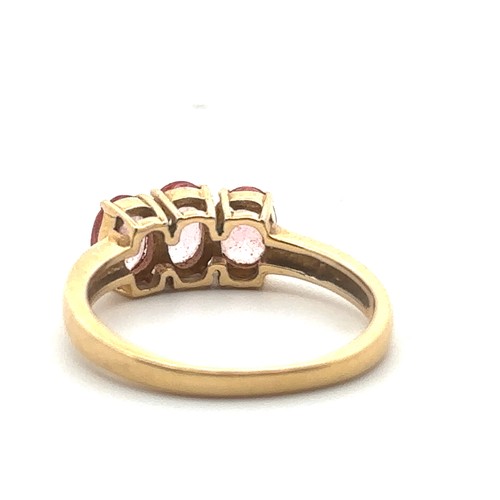 50 - A three stone pink sapphire ring in 18ct yellow gold. Size N. Sapphires each 6mm x 4mm. Hallmarks fo... 