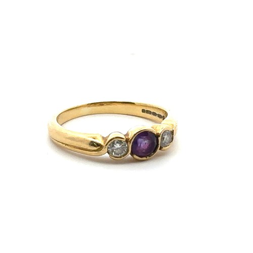 29 - An 18ct gold, amethyst and diamond three stone ring, size M.  Total diamond weight approx 0.14ct. We... 