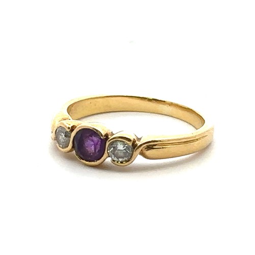 29 - An 18ct gold, amethyst and diamond three stone ring, size M.  Total diamond weight approx 0.14ct. We... 