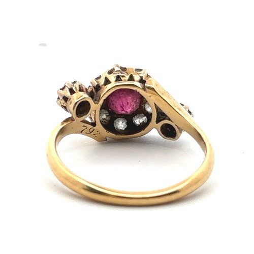 20 - An unusual ruby and old cut diamond cluster ring in a crossover setting and flanked by a ruby on eac... 