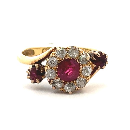 20 - An unusual ruby and old cut diamond cluster ring in a crossover setting and flanked by a ruby on eac... 