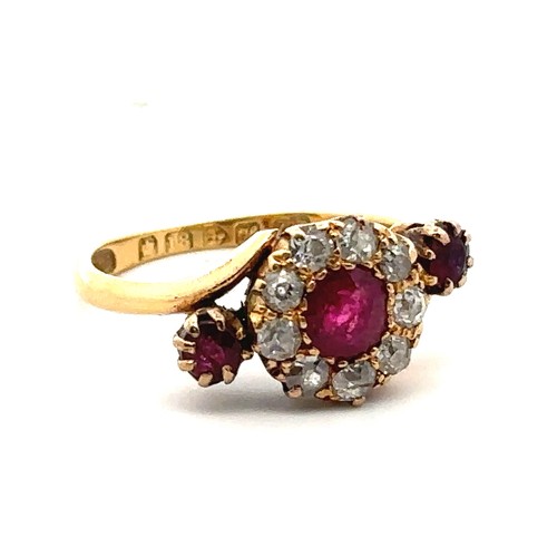 20 - An unusual ruby and old cut diamond cluster ring in a crossover setting and flanked by a ruby on eac... 