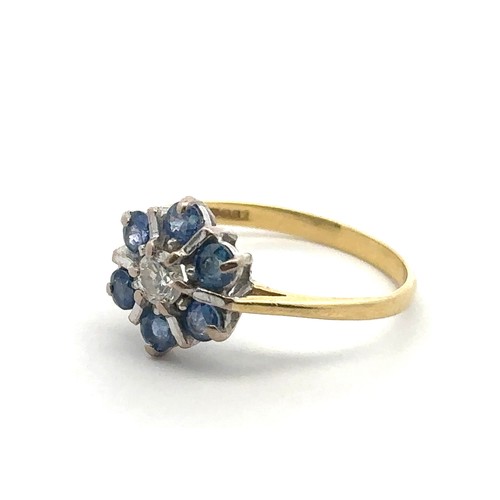 21 - A modern 18ct sapphire and diamond flower ring, size L. Central diamond approx 0.17ct. Hallmarks for... 