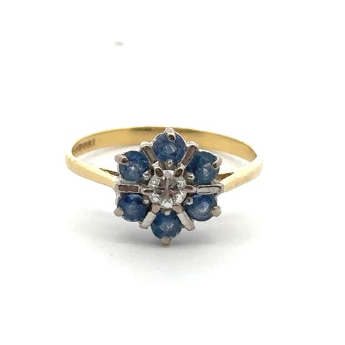 21 - A modern 18ct sapphire and diamond flower ring, size L. Central diamond approx 0.17ct. Hallmarks for... 