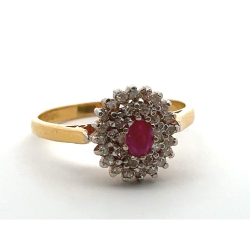 22 - A 22ct gold, ruby and diamond cluster ring. Central oval ruby approx 45mmx 3mm surrounded by a doubl... 