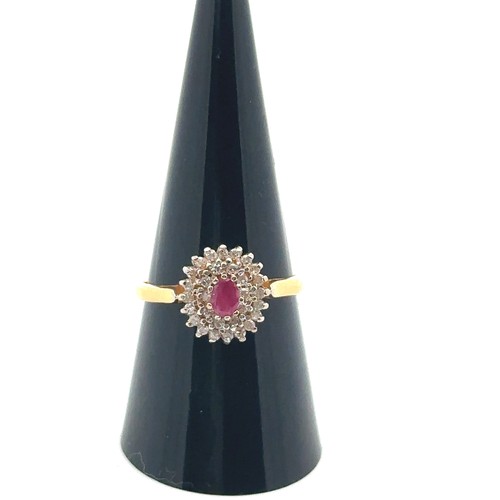 22 - A 22ct gold, ruby and diamond cluster ring. Central oval ruby approx 45mmx 3mm surrounded by a doubl... 