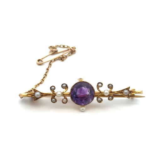 52 - An art nouveau amethyst and seed pearl  brooch stamped 15ct. Length of brooch 46mm. Amethyst with ty... 