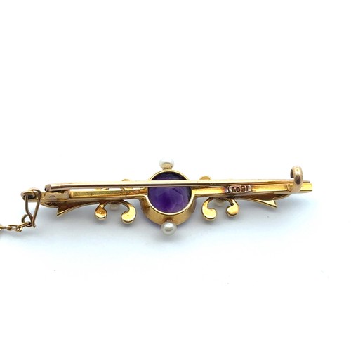 52 - An art nouveau amethyst and seed pearl  brooch stamped 15ct. Length of brooch 46mm. Amethyst with ty... 