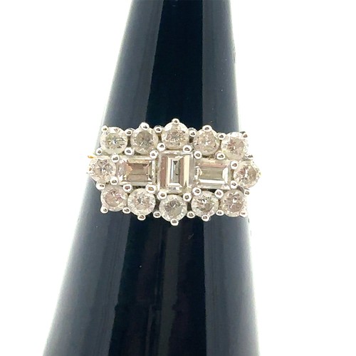 34 - An 18ct and diamond cluster ring - set with three baguette cut diamonds surrounded by 12 round brill... 