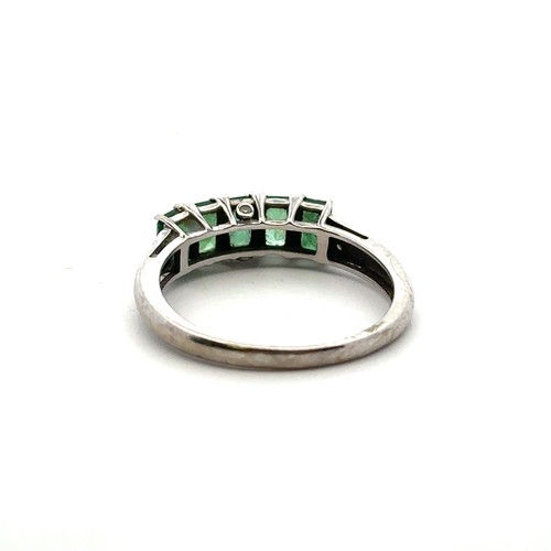 2 - A five stone emerald ring set in 9ct white gold with accent diamond shoulders. Size S.