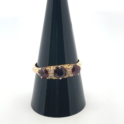 3 - A garnet and diamond ring, size S in a yellow gold scroll mount with a rose gold shank. 4.85g.