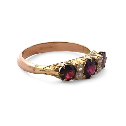 3 - A garnet and diamond ring, size S in a yellow gold scroll mount with a rose gold shank. 4.85g.