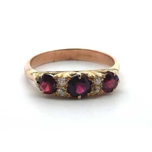 3 - A garnet and diamond ring, size S in a yellow gold scroll mount with a rose gold shank. 4.85g.