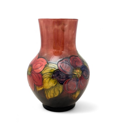 357 - A Moorcroft vase, bulbous shaped, in the flambe clematis pattern.  Height 25cm. Very small dink on o... 