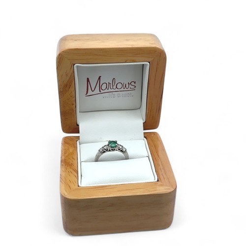 8 - An emerald and diamond ring, size I. Weight 3.35g. Marked as 950 platinum. Central emerald approx 4.... 