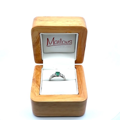 8 - An emerald and diamond ring, size I. Weight 3.35g. Marked as 950 platinum. Central emerald approx 4.... 