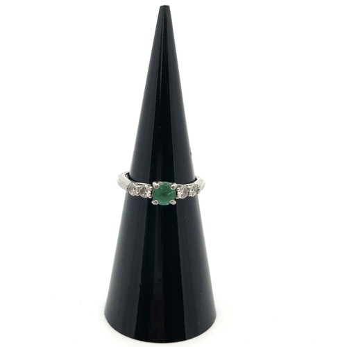 8 - An emerald and diamond ring, size I. Weight 3.35g. Marked as 950 platinum. Central emerald approx 4.... 