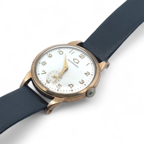 72 - A Garrard 9ct gold watch with sub seconds dial on a black leather strap. Inscribed to back of case -... 