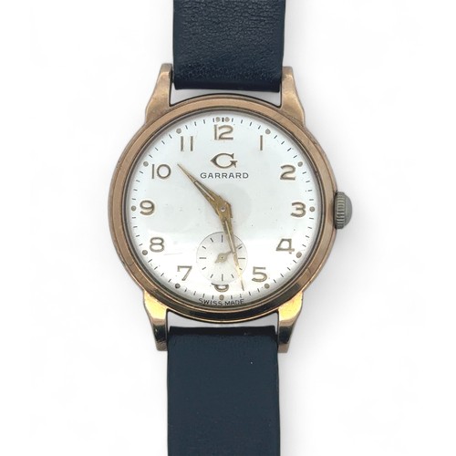 72 - A Garrard 9ct gold watch with sub seconds dial on a black leather strap. Inscribed to back of case -... 