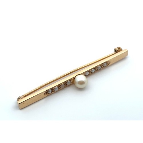 54 - A gold and pearl bar brooch. Unmarked but tested as 15ct using XRF. Length 62mm.