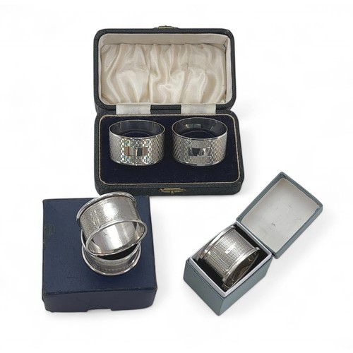 110 - Five hallmarked silver napkin rings, all with blank cartouches - three cased.