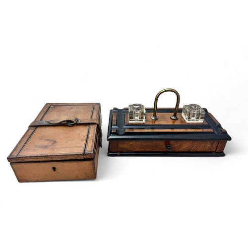 336 - An early 20th Century wooden ink stand with two glass inkwells, a drawer, a brass handle and on four... 