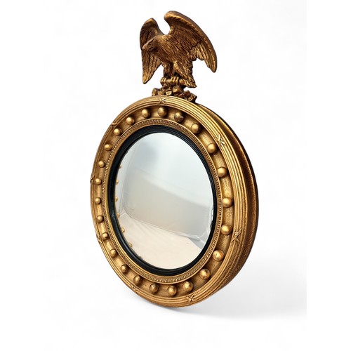 342 - A Regency-style giltwood convex mirror with an ebonised ribbed slip, gilt ball frame and eagle crest... 