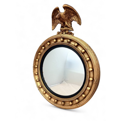 342 - A Regency-style giltwood convex mirror with an ebonised ribbed slip, gilt ball frame and eagle crest... 