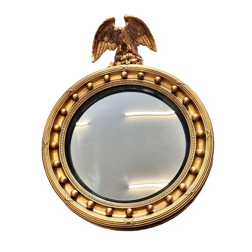 342 - A Regency-style giltwood convex mirror with an ebonised ribbed slip, gilt ball frame and eagle crest... 