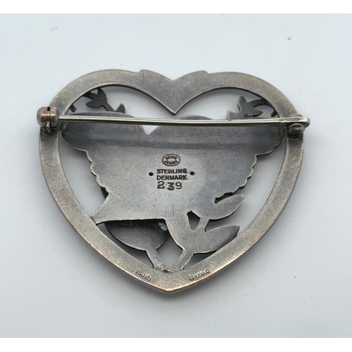 41 - A Georg Jensen silver heart shaped brooch depicting a bird amongst foliage, designed by Arno Malinow... 