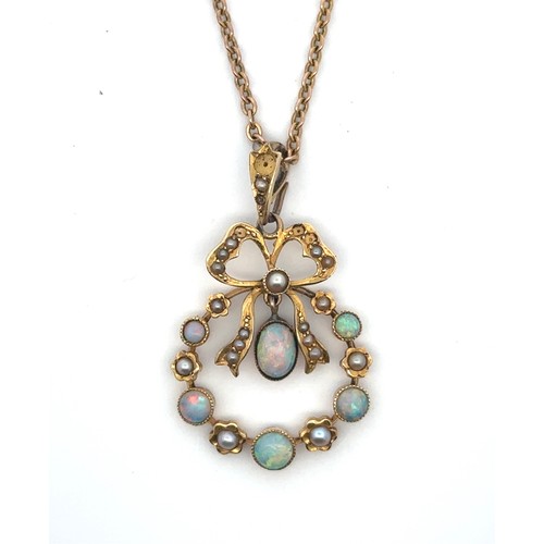 11 - An art nouveau opal pendant with bow crest stamped 15ct on a 16