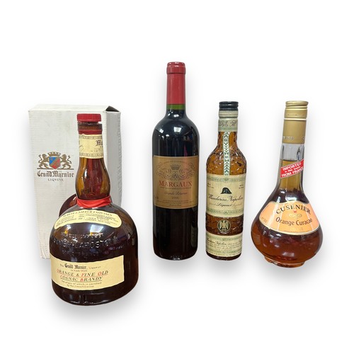 183 - Four Bottles Of Alcohol. 700ml bottle of Grand Mariner triple orange liqueur, cork has broken where ... 