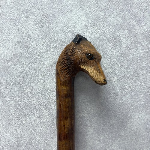 147A - A walking stick with the handle carved with the head of a fox with glass eyes, in the style of Swain... 