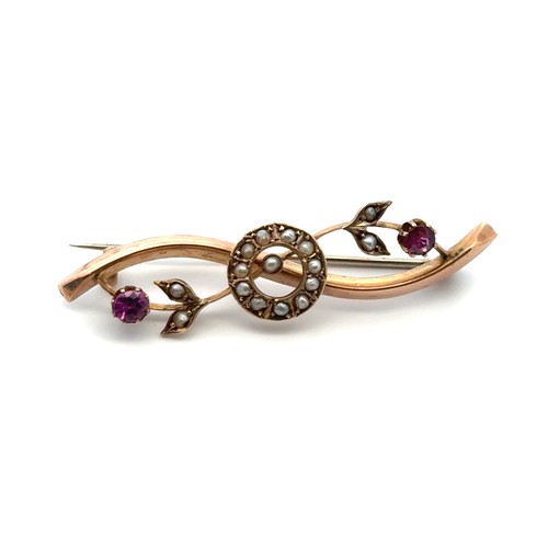 31 - 9ct brooch set with purple paste stones and seed pearls. Length 45mm. Weight 2.29g. Stamped TXS with... 