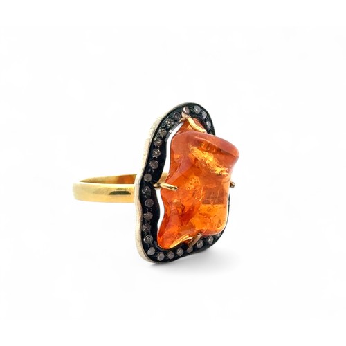 26 - An 18ct gold and silver-topped ring set with an unusual freeform mandarin garnet and thirty three su... 