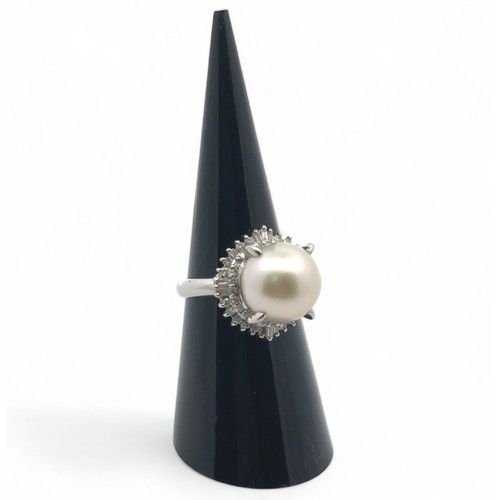 75 - A pearl and diamond ring set in platinum, size L. The large white freshwater pearl is surrounded by ... 