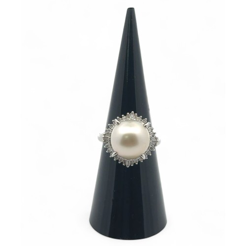 75 - A pearl and diamond ring set in platinum, size L. The large white freshwater pearl is surrounded by ... 