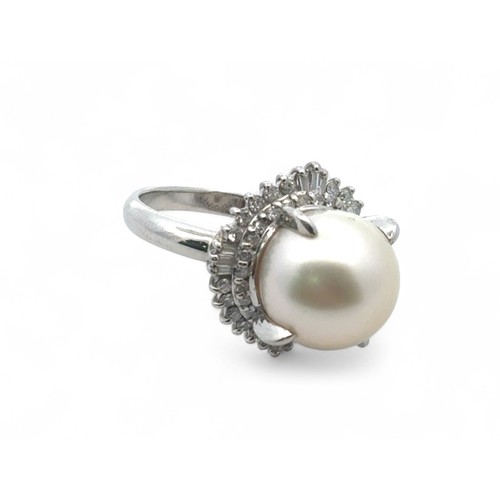 75 - A pearl and diamond ring set in platinum, size L. The large white freshwater pearl is surrounded by ... 