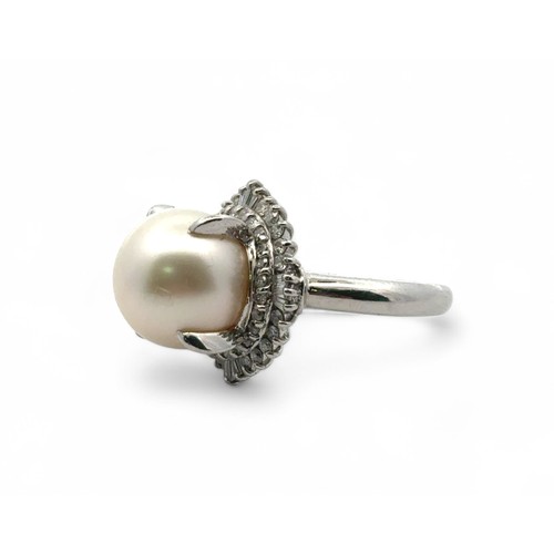 75 - A pearl and diamond ring set in platinum, size L. The large white freshwater pearl is surrounded by ... 