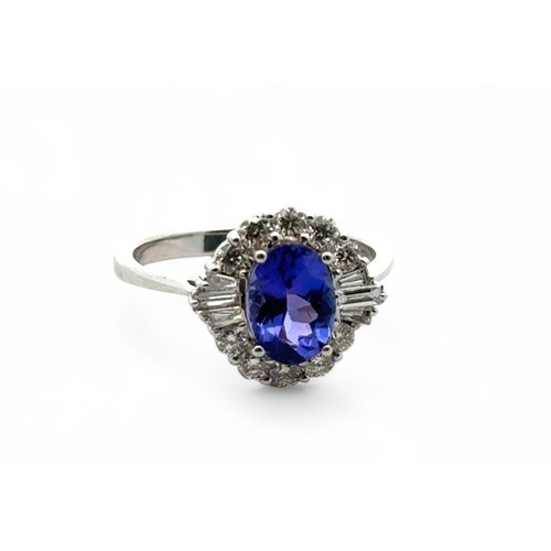 49 - A stunning tanzanite and diamond cluster ring, size N. The oval tanzanite of 1.54ct is surrounded by... 