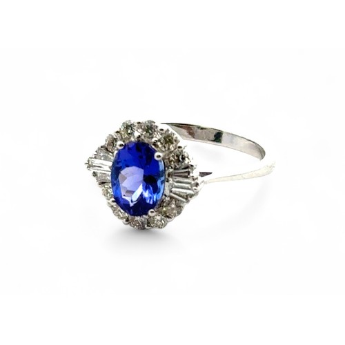 49 - A stunning tanzanite and diamond cluster ring, size N. The oval tanzanite of 1.54ct is surrounded by... 