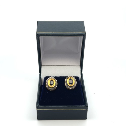 18 - A pair of oval sapphire and round cut diamond halo stud earrings, set in gold plated silver. Sapphir... 