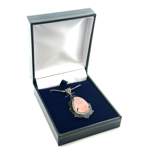 79 - An unusual silver pendant set with a large carved pear-shaped morganite and diamonds, with black ena... 