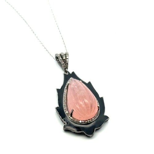 79 - An unusual silver pendant set with a large carved pear-shaped morganite and diamonds, with black ena... 