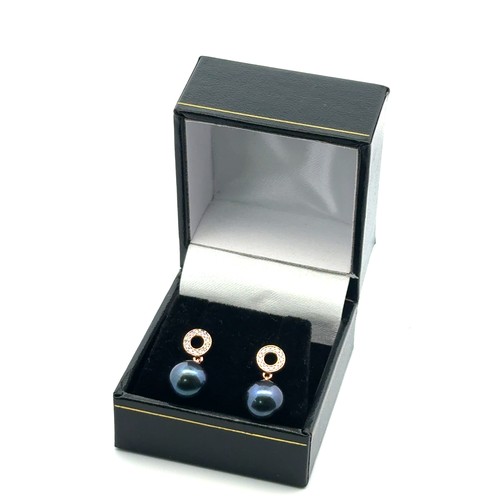 66 - A pair of rose gold iridescent dark pearl droplet earrings with diamond set halo bails.