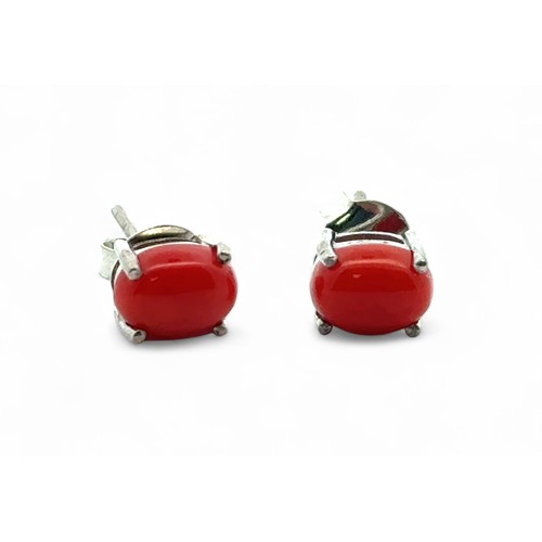 92 - A pair of oval cabochon coral silver stud earrings.