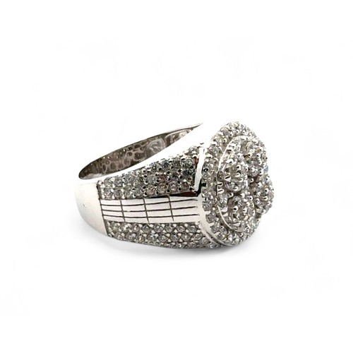 101 - A silver dinner ring heavily set with white round cubic zirconias, size J/K.